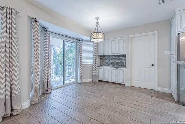 a kitchen with stainless steel appliances granite countertop a sink a stove a refrigerator and island with wooden floor