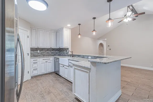 an empty room with wooden floor and ceiling fan