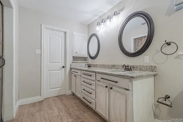 a bathroom with a granite countertop sink vanity and mirror