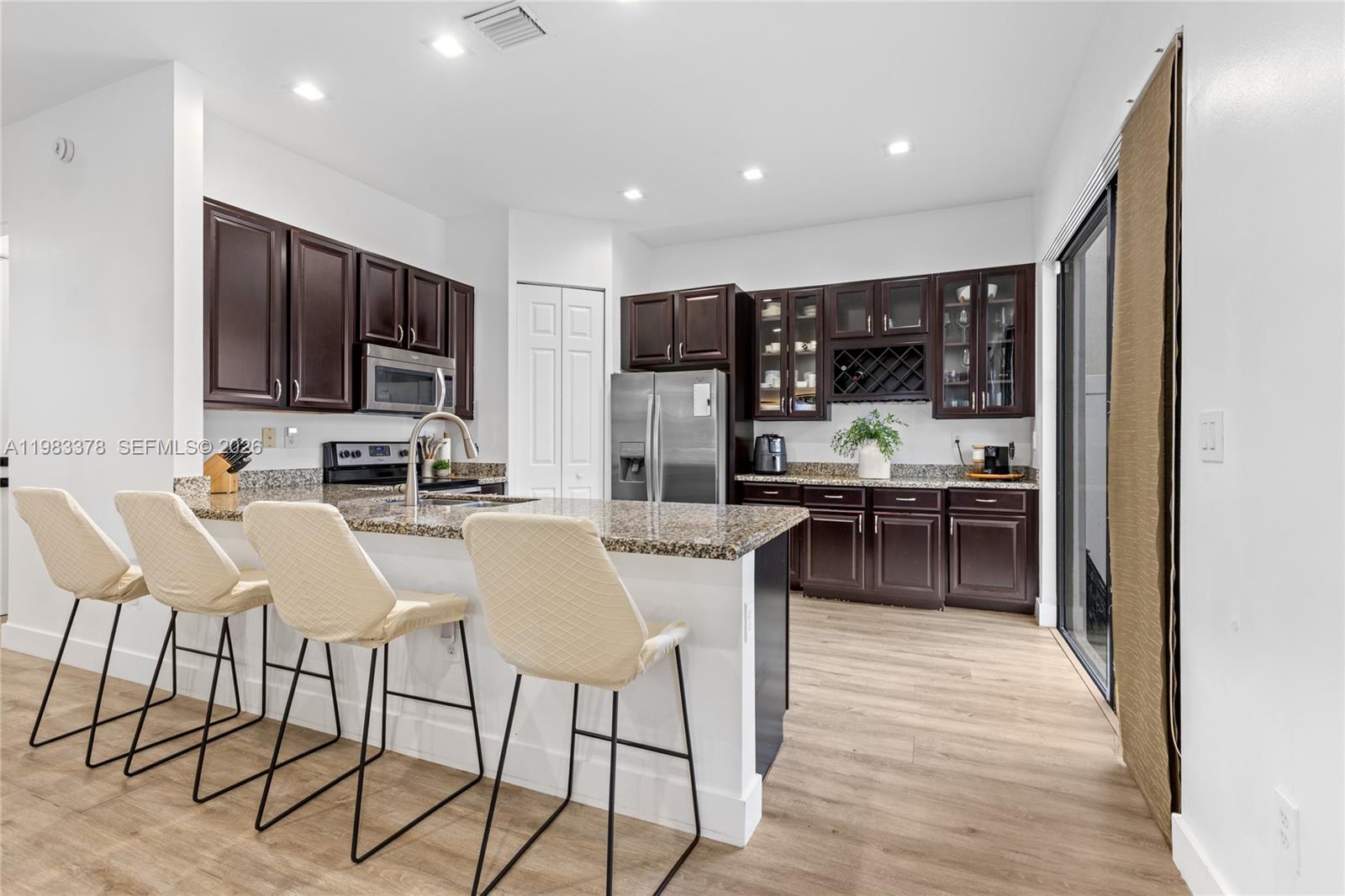 9094 Southwest 36th Street Miramar, FL 33025 - Photo 11 of 50 a kitchen with stainless steel appliances kitchen island granite countertop a sink and cabinets