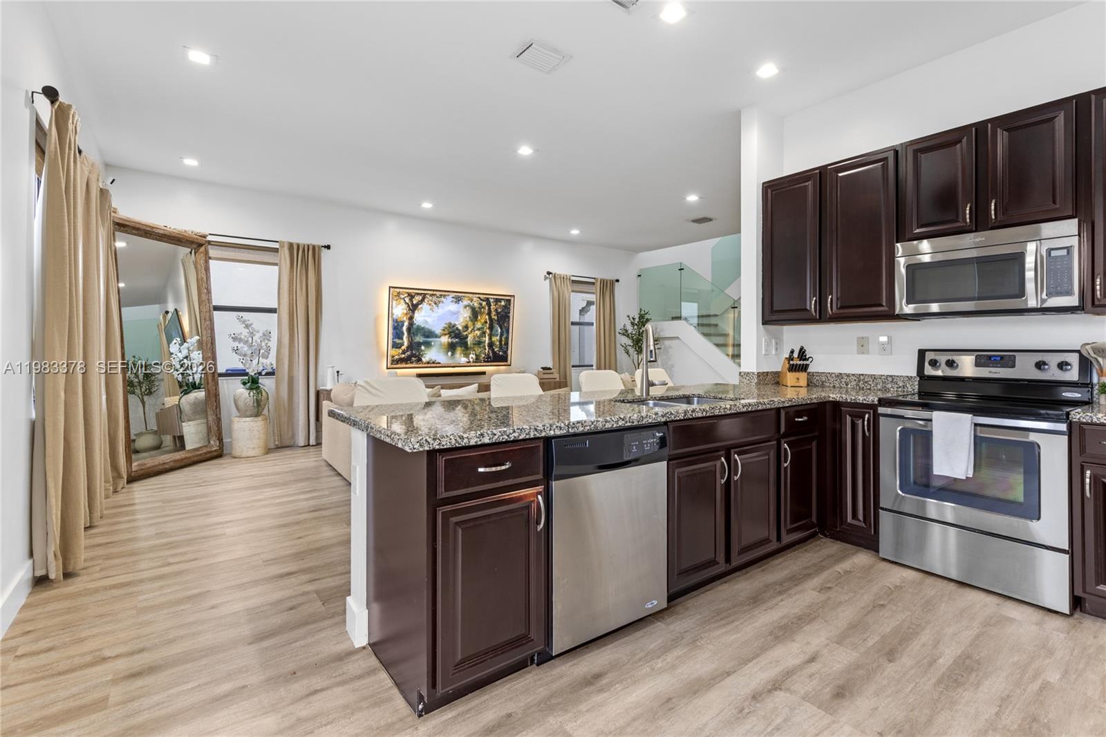 9094 Southwest 36th Street Miramar, FL 33025 - Photo 12 of 50 a kitchen with stainless steel appliances kitchen island granite countertop a stove top oven and sink