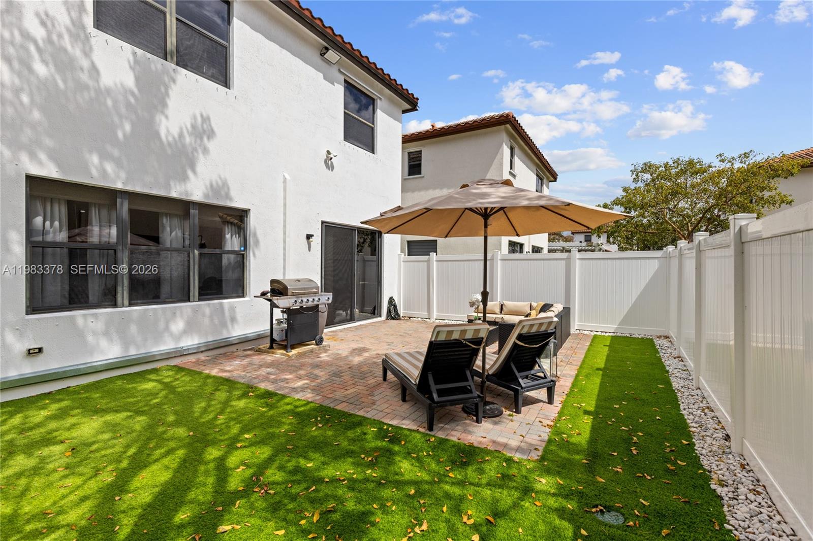 9094 Southwest 36th Street Miramar, FL 33025 - Photo 42 of 50 a view of backyard with table and chairs under an umbrella with wooden fence