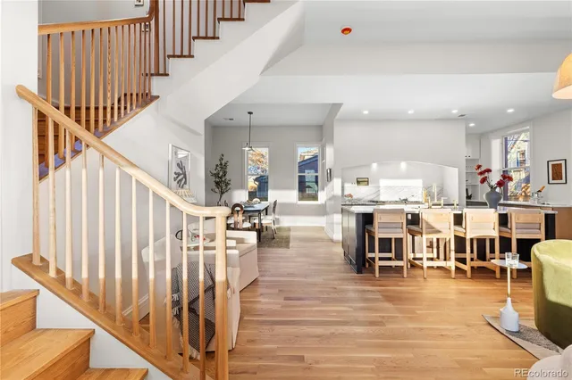a living room with lots of furniture and a dining table with wooden floor