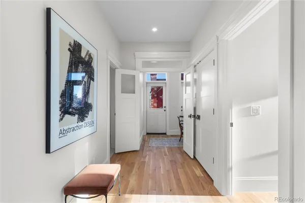 a view of a hallway with wooden floor and furniture