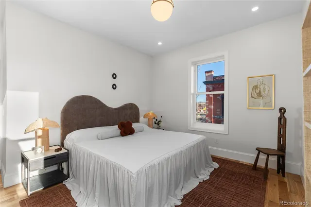 a bedroom with a bed and wooden floor