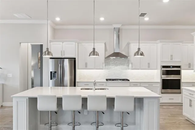 a kitchen with stainless steel appliances kitchen island granite countertop a kitchen island and chairs in it