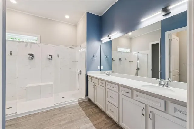 a spacious bathroom with a shower sink and mirror
