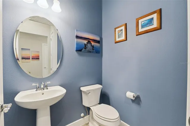 a bathroom with a toilet a sink and mirror