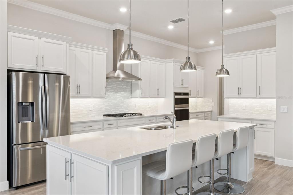 2745 Nature Vw Road St. Cloud, FL 34771 - Photo 4 of 50 a kitchen with kitchen island a stove a refrigerator a sink and chairs