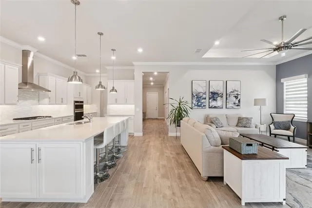 a large white kitchen with lots of counter space a sink and appliances