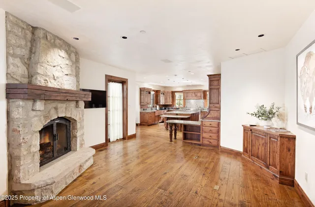 a living room with furniture a fireplace and a kitchen view