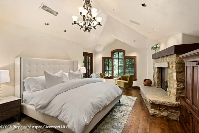 a bed room with a bed mirror and a chandelier