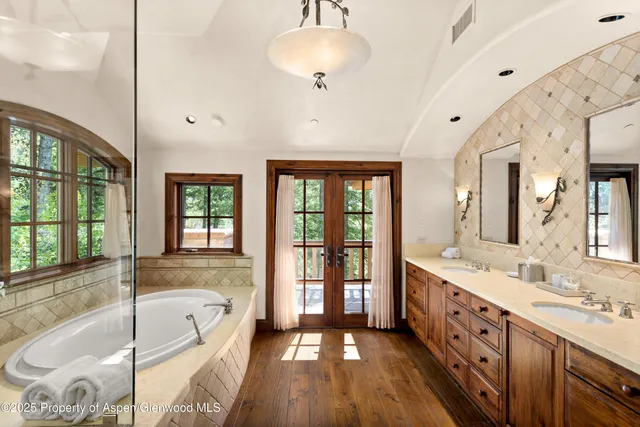 a spacious bathroom with a tub sink shower and mirror