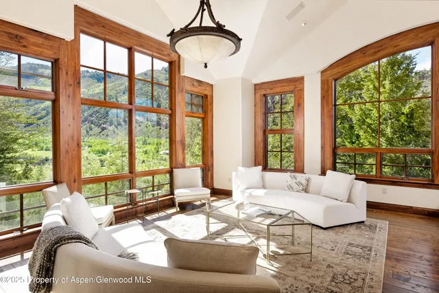 a living room with furniture and floor to ceiling windows