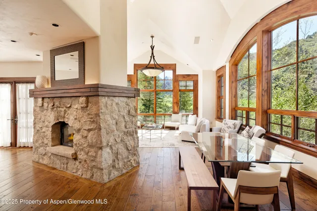 a living room with furniture a fireplace and floor to ceiling windows