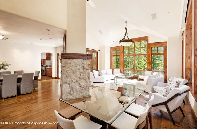 a living room with fireplace furniture and a large window
