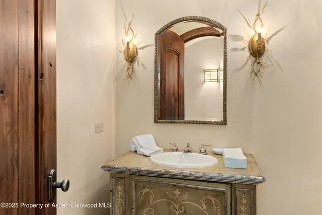 a bathroom with a granite countertop sink a mirror and shower