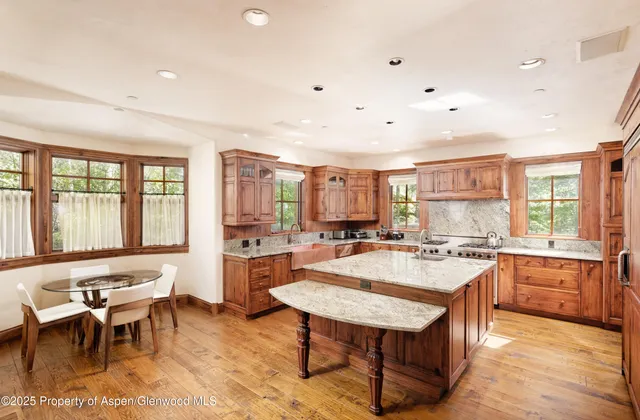 a large kitchen with cabinets table and chairs