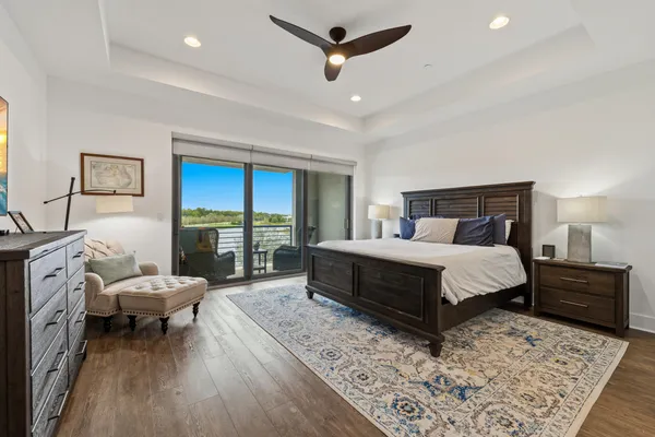 a bedroom with a bed a chandelier and a rug