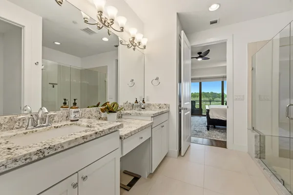 a en suite bathroom with a double vanity sink and a mirror