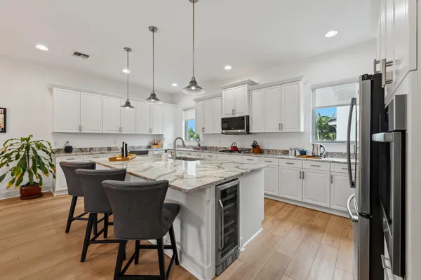 a kitchen with appliances a sink and chairs