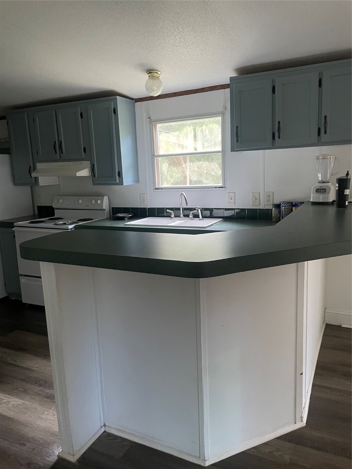 18759 Fire Fly Drive Porter, TX 77365 - Photo 10 of 11 a kitchen with granite countertop a sink a stove and cabinets