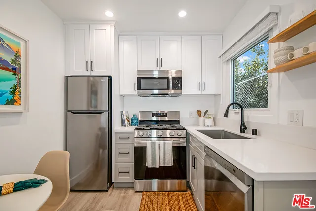 a kitchen with stainless steel appliances granite countertop a stove a sink dishwasher a refrigerator and a microwave