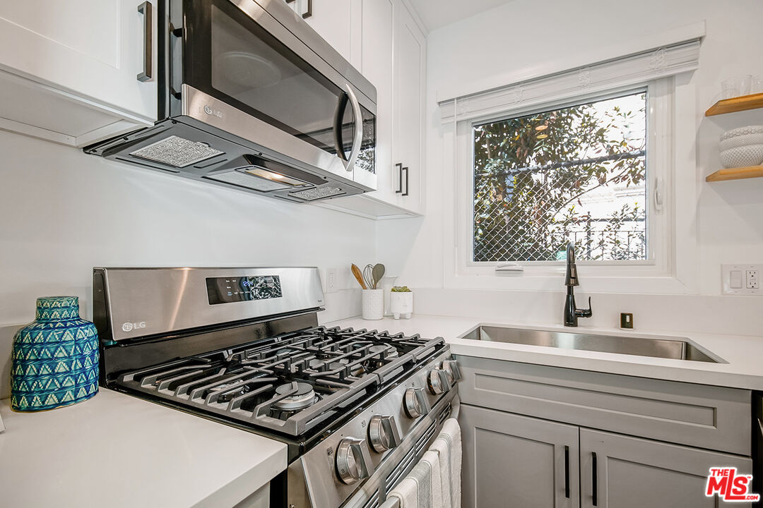 1217 9th Street, Unit 9 Santa Monica, CA 90401 - Photo 10 of 14 a kitchen with a stove a sink and a window