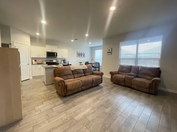 a living room with furniture kitchen view and a refrigerator