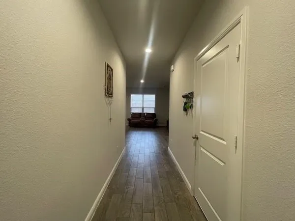 a view of a hallway with wooden floor and staircase