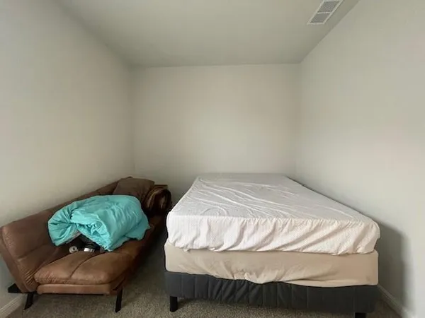 a bedroom with a bed and a chair