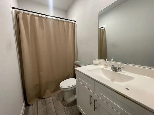 a bathroom with a sink a toilet and shower