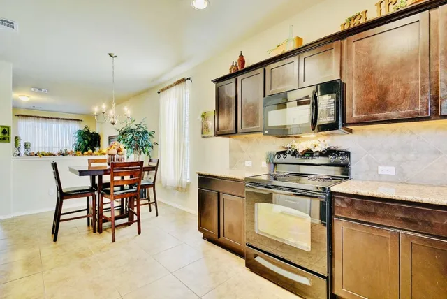 a kitchen with stainless steel appliances granite countertop a stove a sink and a refrigerator