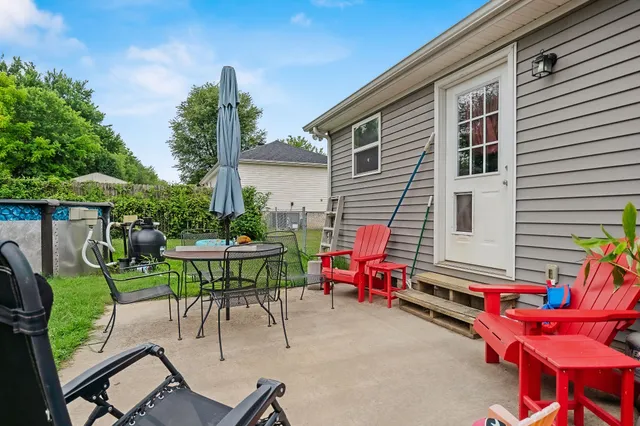 a backyard of a house with table and chairs