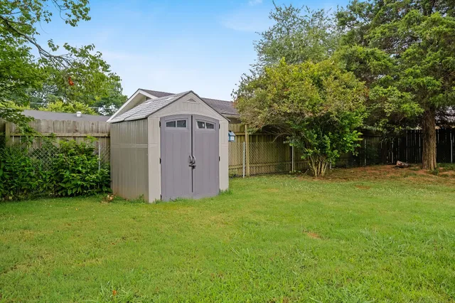 a front view of a house with a yard and trees
