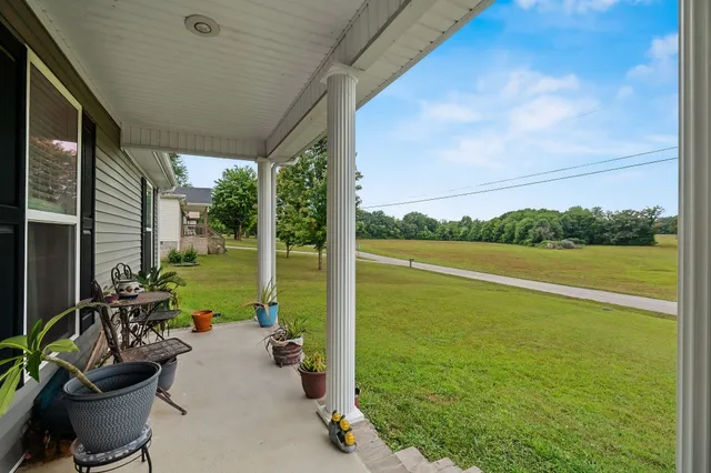 a view of a patio with lawn chairs floor to ceiling window and yard