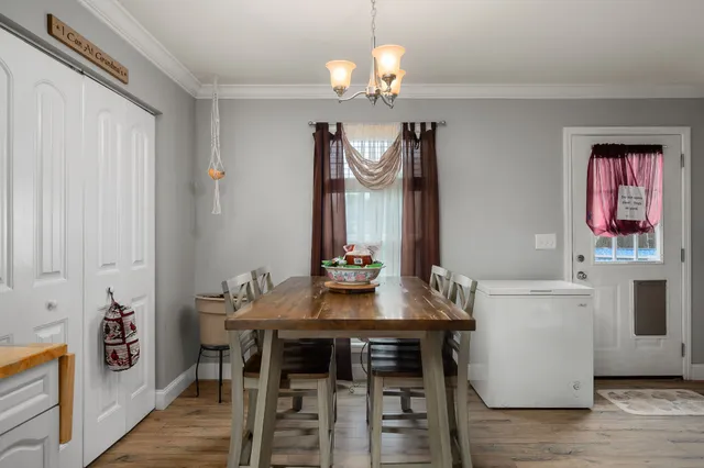 a view of a dining room with furniture and chandelier