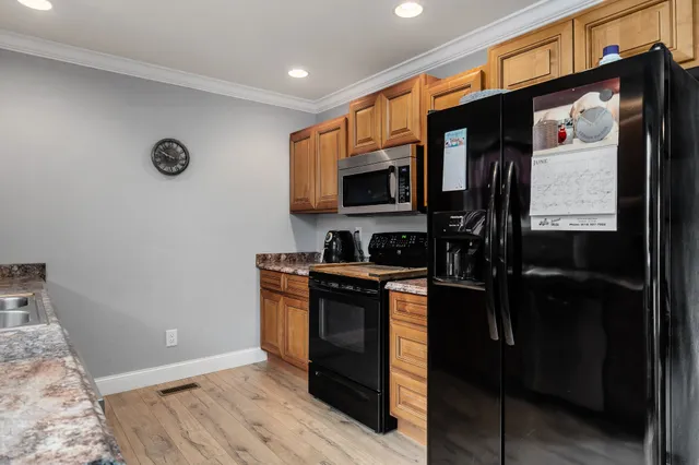 a kitchen with stainless steel appliances granite countertop a refrigerator a stove a sink and a microwave