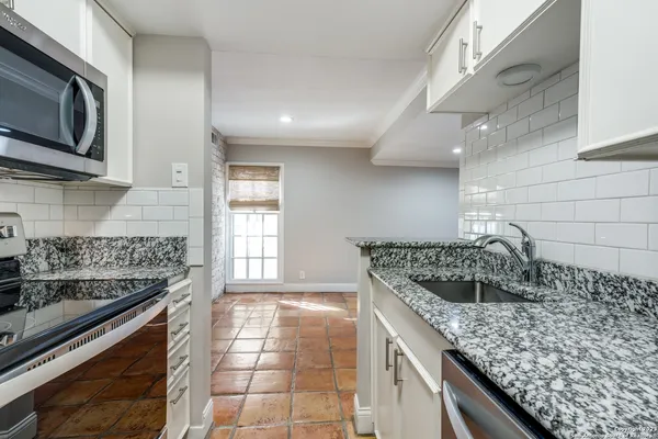 a kitchen with stainless steel appliances granite countertop a sink and stove