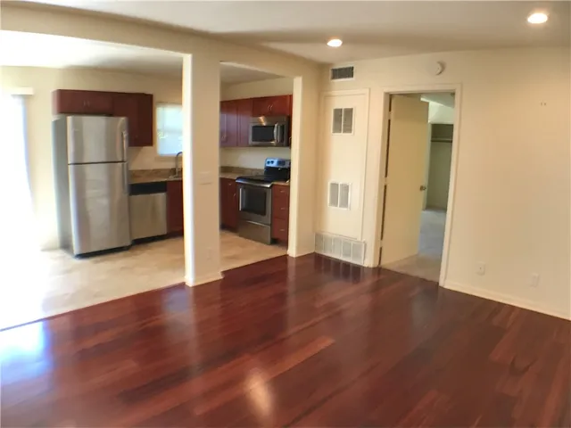 a view of kitchen view wooden floor and electronic appliances