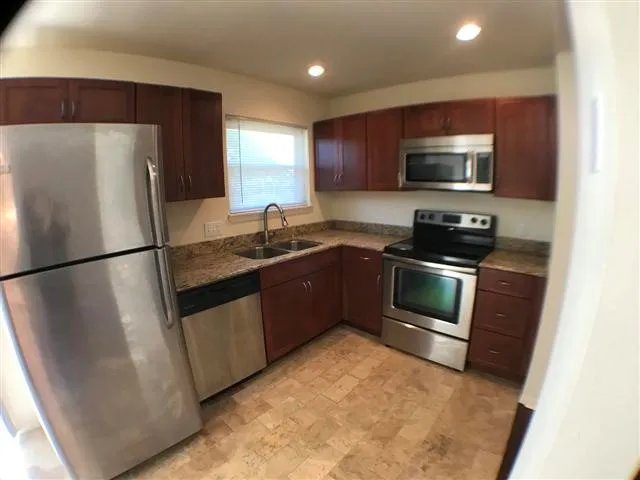 a kitchen with stainless steel appliances granite countertop a refrigerator a sink a stove a microwave and cabinets