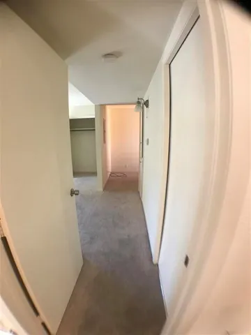 a view of a hallway with wooden floor and entryway