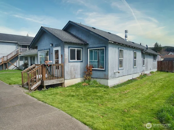 a view of a house with a yard and deck area