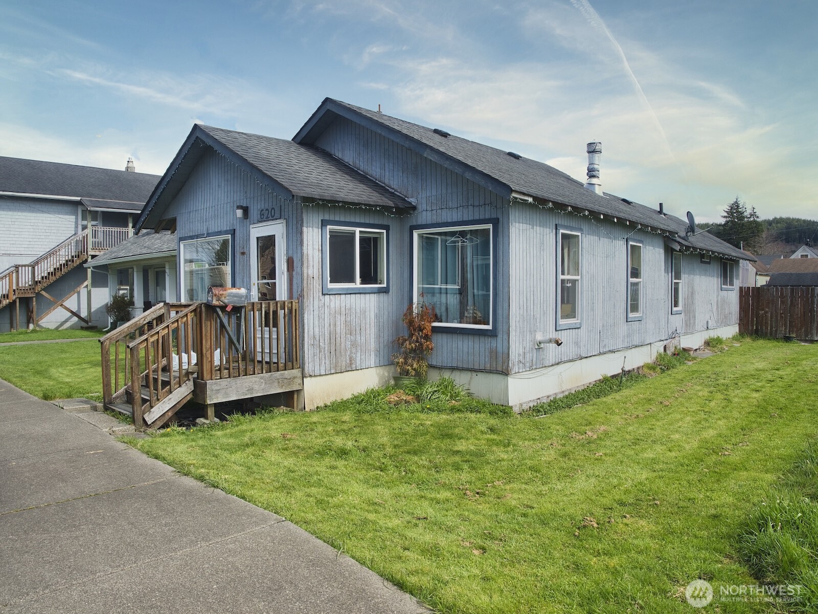 a view of a house with a yard and deck area
