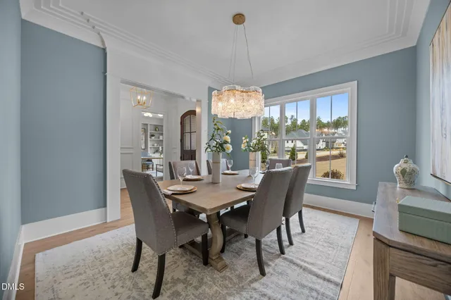 a kitchen with a table chairs and white cabinets