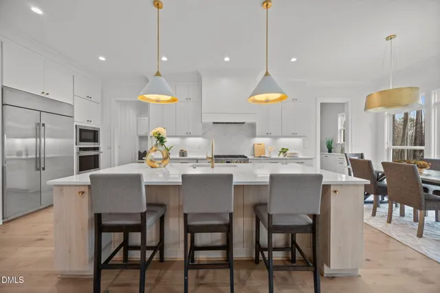 a large white kitchen with lots of counter space and a sink