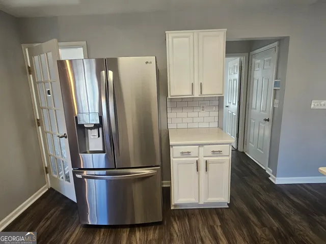 a kitchen with stainless steel appliances a refrigerator and wooden floor