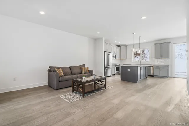 a living room with furniture and kitchen view