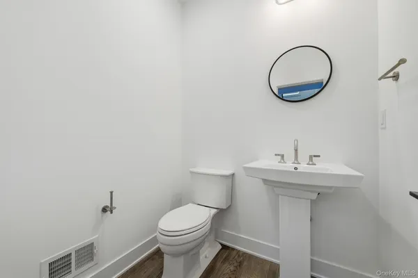 a bathroom with a sink a toilet and a mirror