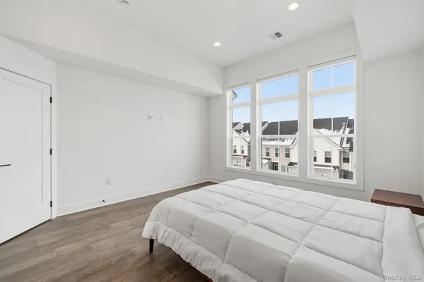 a bedroom with a bed and a large window